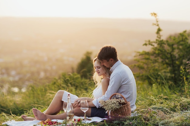 paar zitten op picknick en ontspannen in de natuur