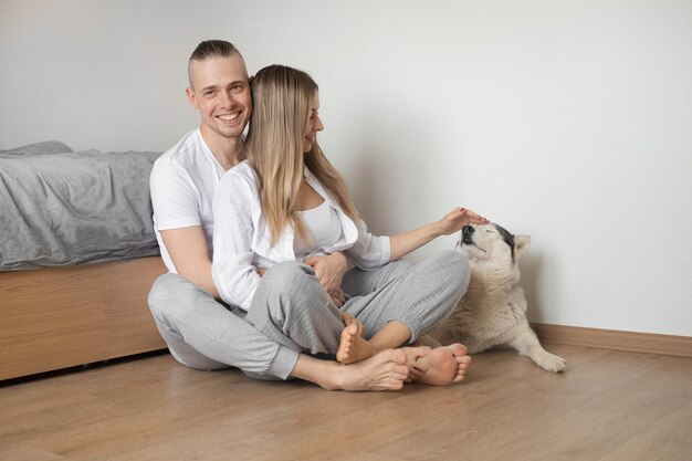 paar zittend op de vloer een hond aaien