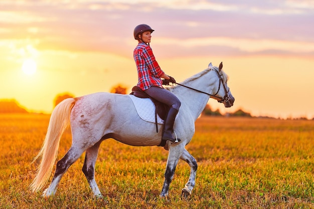 Paardrijden over de weide tijdens zonsondergang