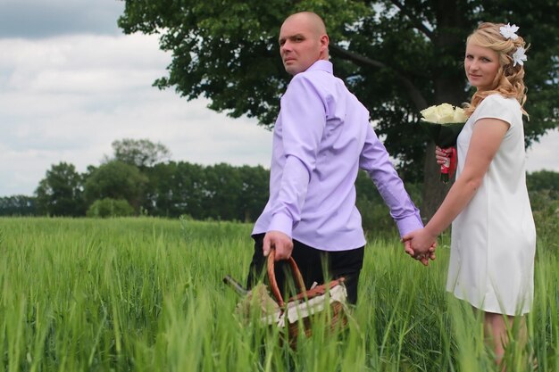 Paarliefhebbers wandelen in een groen veld in de zomerdag