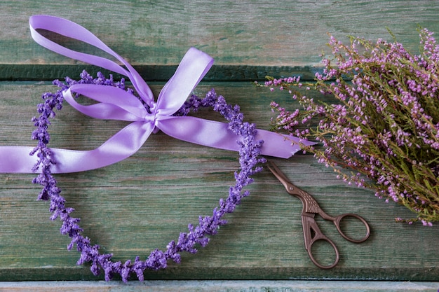 paars hart van paarse bloemen, schaar in de vorm van een vogel en een heather boeket