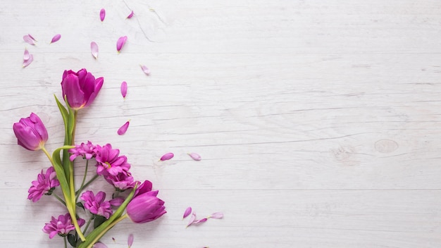 Paarse bloemen met bloemblaadjes op tafel