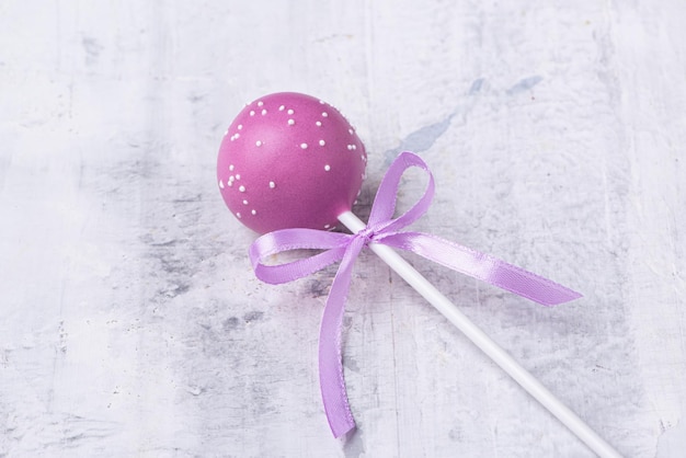 Paarse cakepop op een gestructureerde achtergrond