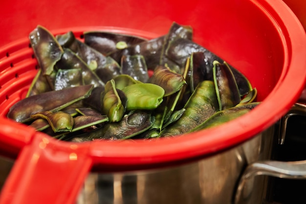 Paarse erwten liggen in een plastic pot in de keuken