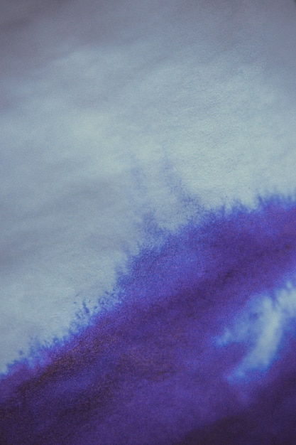 Foto paarse inktvlek op een vel wit papier macro. abstracte achtergrond. verspreidt inktvlekken met strepen op een witte achtergrond