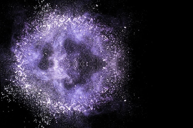 Foto paarse kleur poeder explosie op zwarte achtergrond.