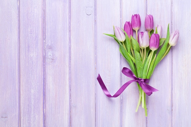 Paarse tulpen over houten tafel