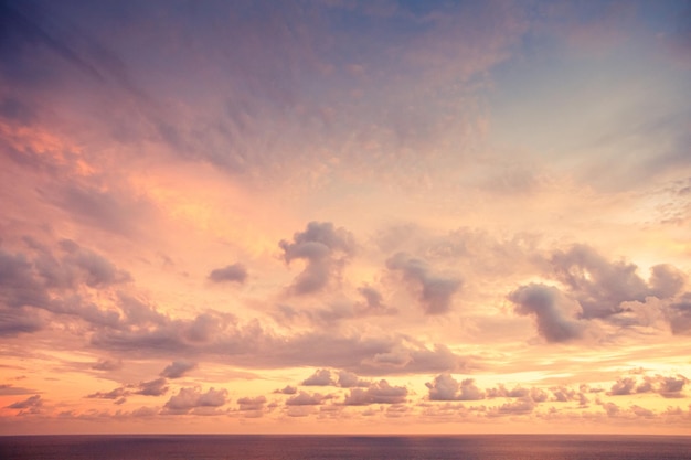 Paarse zonsondergang met kalme oceaan en wolken