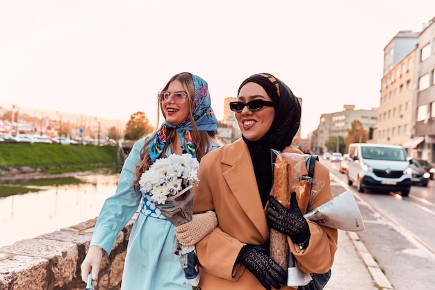 Paarvrouw één die een hijab draagt en een moderne maar toch traditionele kleding en andere in een blauwe kleding