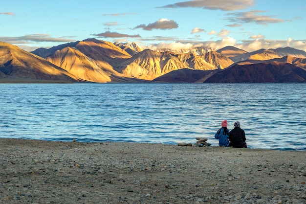 Paarzitting Zie de zonsopgang bij Pangong-meer, Ladakh, India.