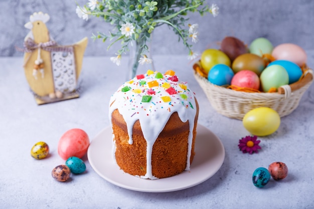 Paascake met fruit en gekleurde eieren en bloemen op grijze achtergrond