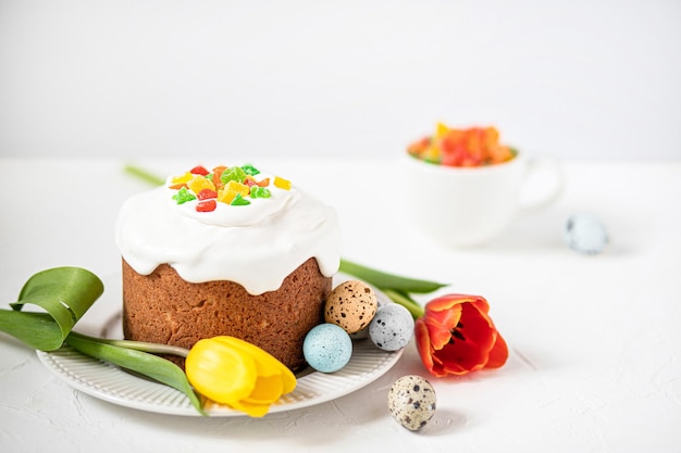 Paascompositie met traditionele paascake beschilderde kwarteleitjes en tulpen selectieve focus