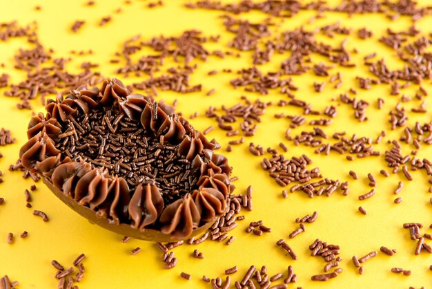 Paasei gevuld met gegranuleerde chocolade Paasconcept op gele achtergrond