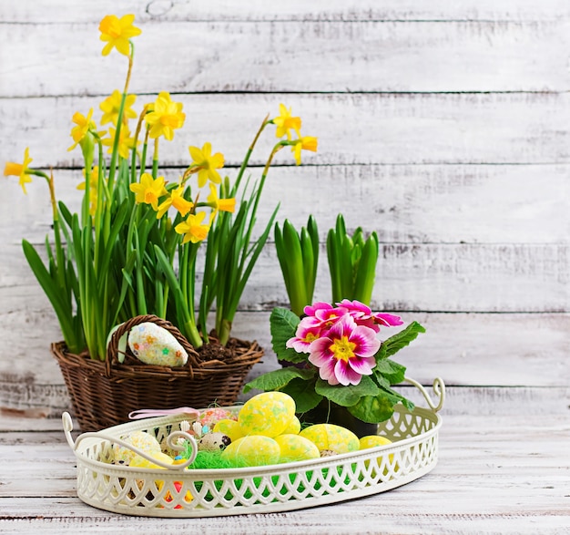 Paaseieren en bloemen op een lichte houten tafel