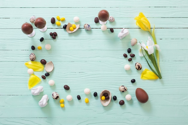 Paaseieren en bloemen op groene houten oppervlak