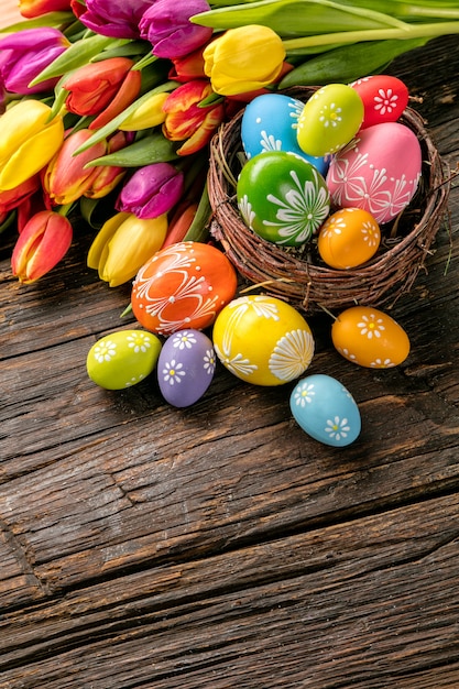 Paaseieren en tulpen op houten planken