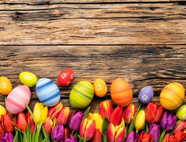 Paaseieren en tulpen op houten planken