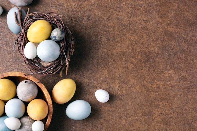 Paaseieren geel grijs blauw liggen in een nest