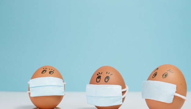 paaseieren in een beschermend medicijnmasker op een blauwe achtergrond