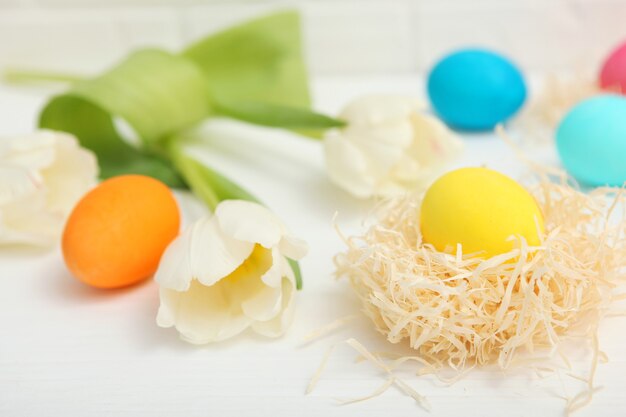 Paaseieren in een mand en bloemen op tafel