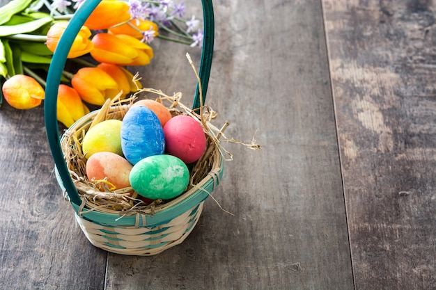 Paaseieren in een mand en tulpen