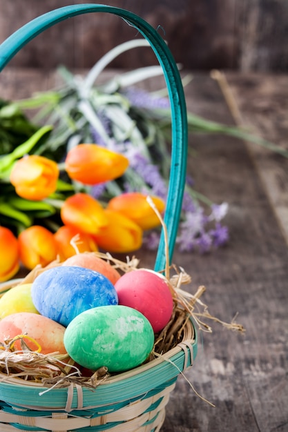 Paaseieren in een mand en tulpen