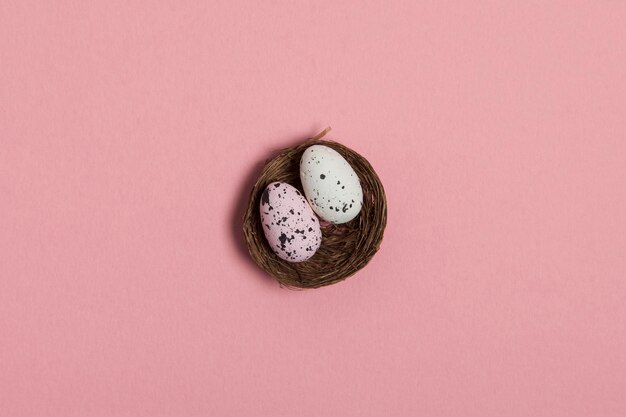 Paaseieren in een nest op een pastelroze achtergrond