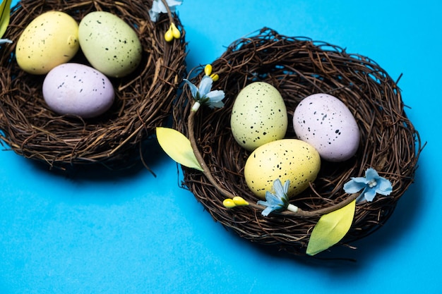 Paaseieren in rieten nestmanden op een blauwe achtergrond