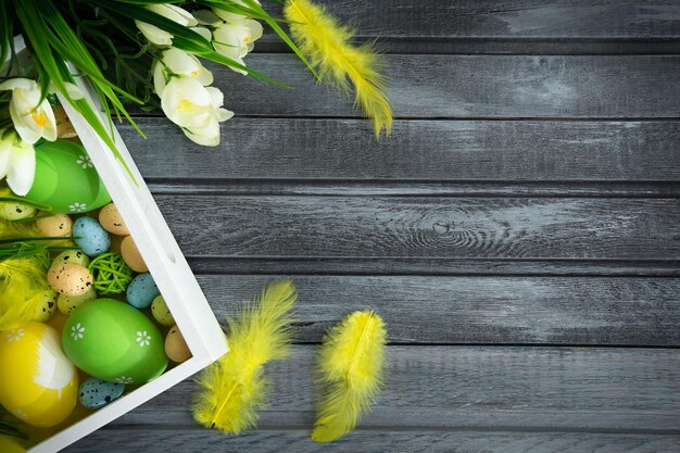 Paaseieren met bloemen op een houten bord het concept van de paasvakantie Ruimte voor tekst kopiëren