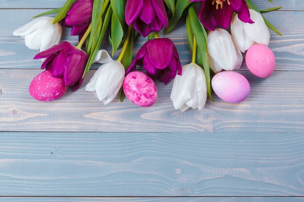 Paaseieren met tulpen op blauwe houten