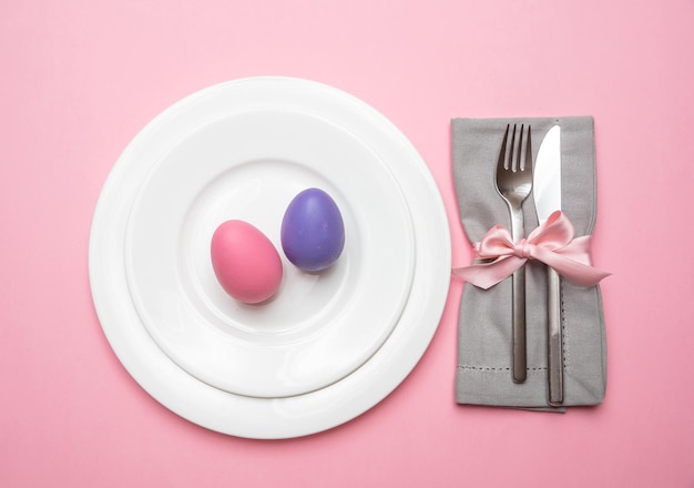 Paaseieren pastelkleuren geschilderd in een witte plaat roze kleur achtergrond