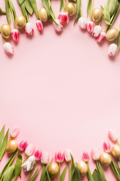 Paasgroetekaartje met tulpen, eieren en een konijn op roze achtergrond met kopieerruimte