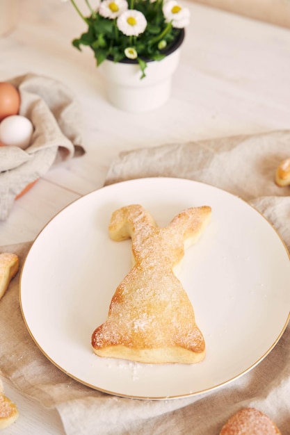 Paashaaskoekjes, paaseieren en ingemaakte bloemen op een witte houten tafel