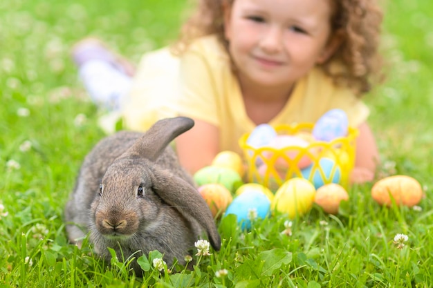 Paasjongen meisje heel peri oren klein konijn konijntje jaagt op kleurrijke eieren op groen gras voorjaarsvakantie
