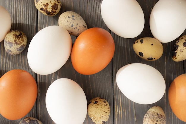 Paaskip en kwarteleitjes van natuurlijke kleuren op een houten ondergrond plat leggen