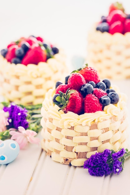 Paasmand minicakes met geglazuurd vers fruit erop.