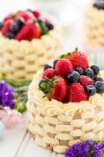 Paasmand minicakes met geglazuurd vers fruit erop.