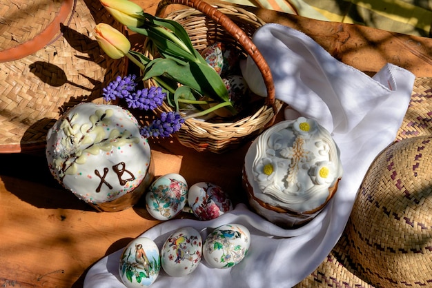 Paastaarten eieren en gele tulpen en violette bloemen in een mand op Paasdag