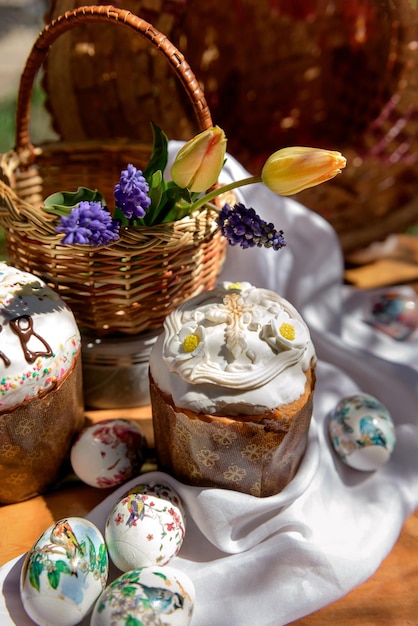 Paastaarten eieren en gele tulpen en violette bloemen in een mand op Paasdag