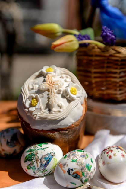 Paastaarten eieren en gele tulpen en violette bloemen in een mand op Paasdag