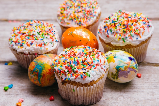 Paastaarten en beschilderde eieren. cupcakes versierd met hagelslag. feestelijk traditioneel vakantievoedsel gebakken gebak