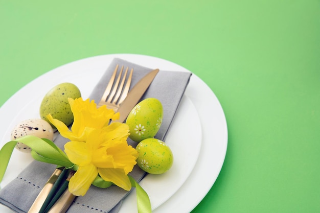 Paastafel Geel Lentebloemen servet en gouden bestek op witte borden