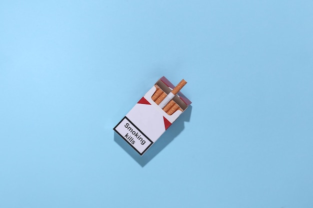 Pack of cigarettes on blue bright background. Smoking kills. Top view