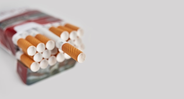 Pack full of filtered cigarettes on a gray surface