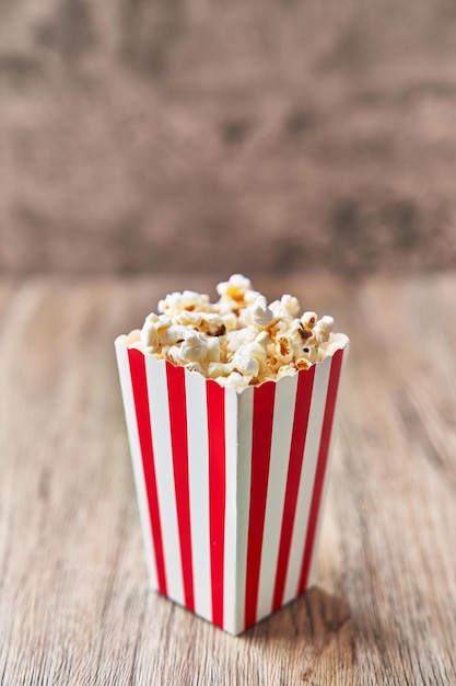 Pack of salty popcorns on a wooden surface