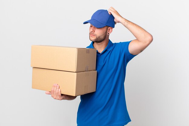 Package deliver man feeling puzzled and confused, scratching head