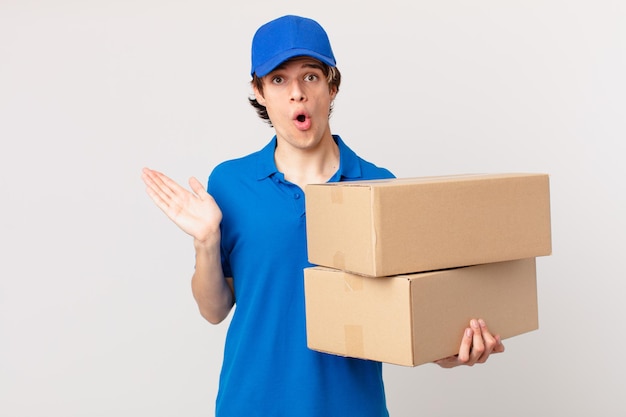 Package deliver man looking surprised and shocked, with jaw dropped holding an object