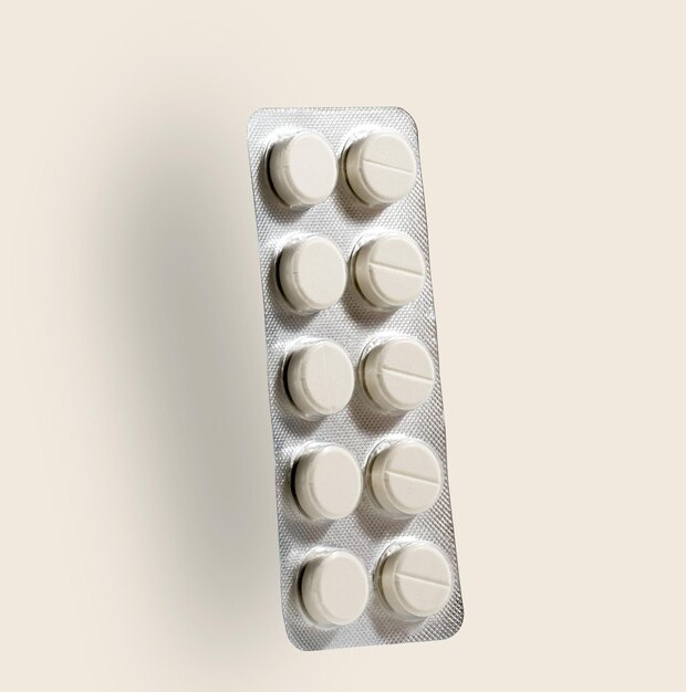 Package of tablets isolated on light yellow background