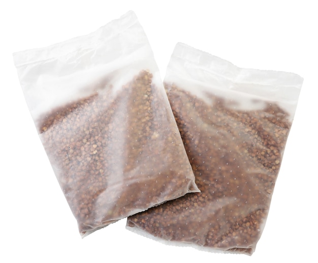 Packages with dry buckwheat for cooking close-up are flying on a white background. Isolated