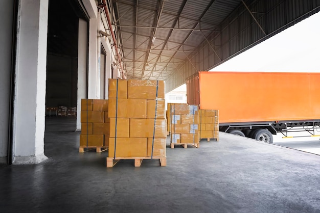 Packaging boxes stacked on pallets loading with shipping cargo\
container freight trucks logistics